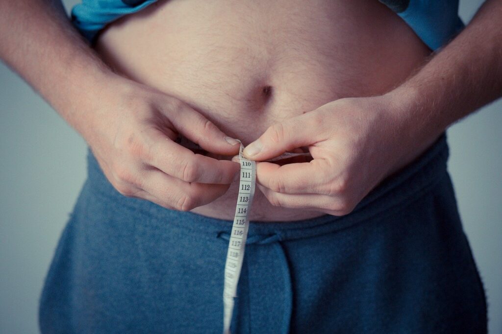 man measuring his stomach